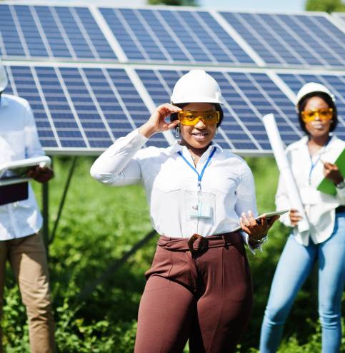 African american technician checks the maintenance of the solar panels. Group of three black engineers meeting at solar station.